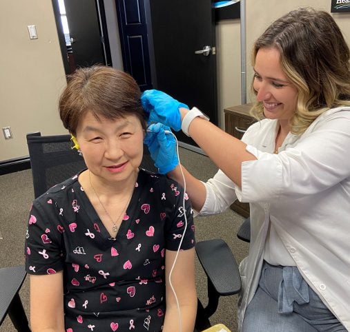 Annie Young performing a hearing test on a patient