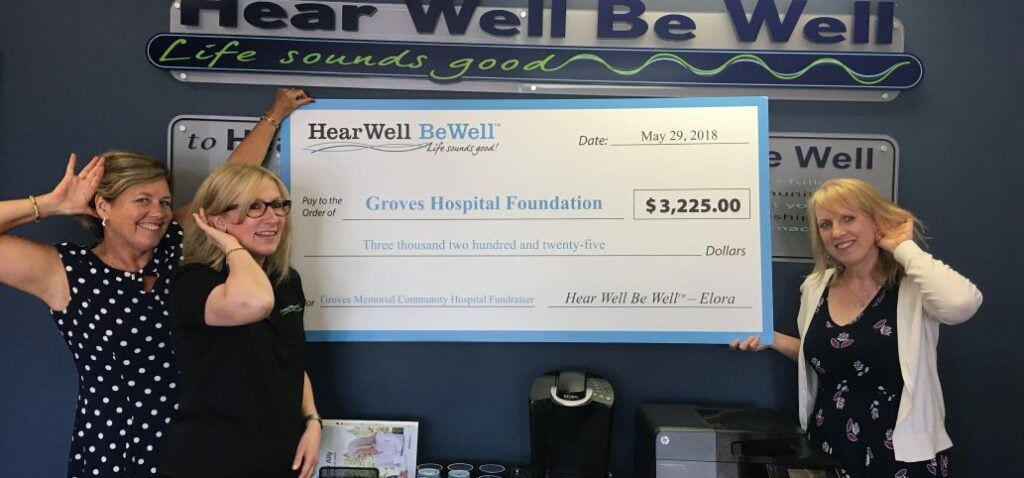 Women holding up a big cheque from Hear Well Be Well