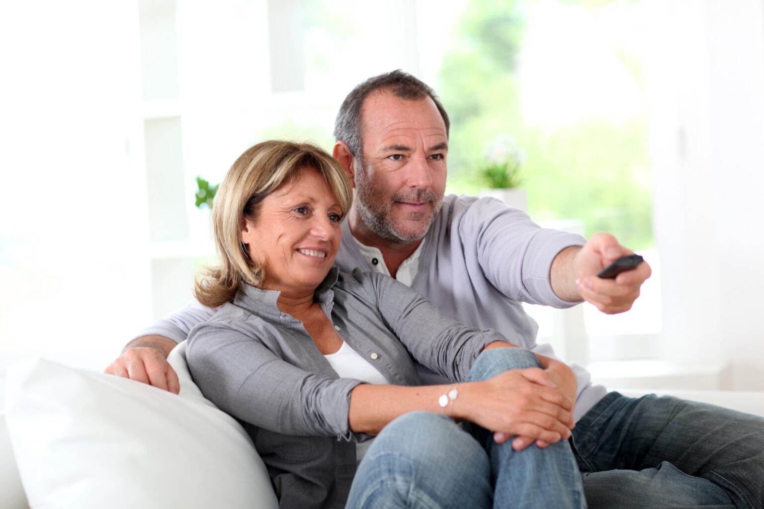 Couple sitting on couch watching TV