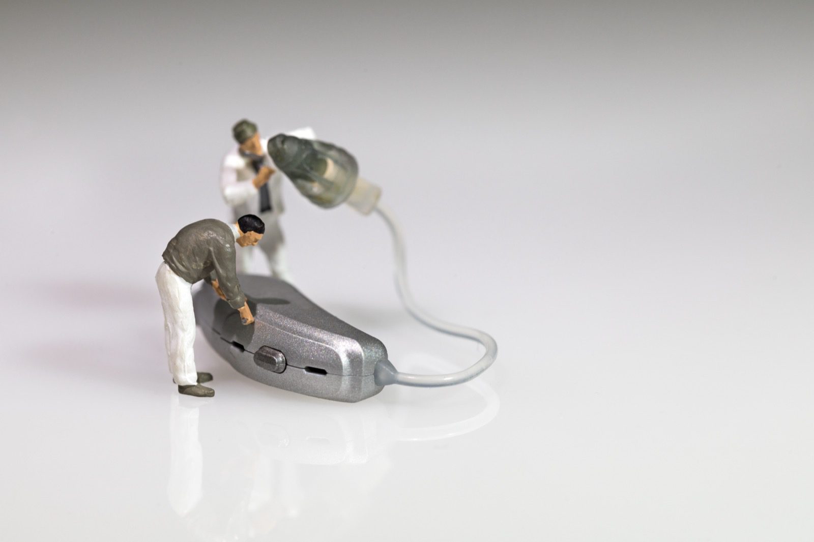 Miniature figures working on a hearing aid